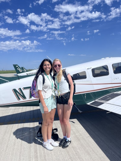 Students posing with an airplane