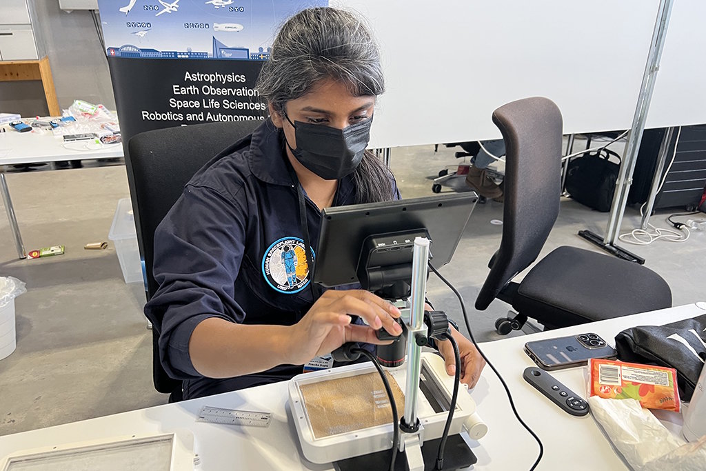 Pranika Gupta examines samples showing lunar dust contamination on spacesuit fabrics