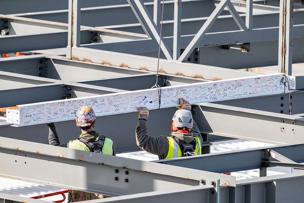 Final beam for flight operations building is hoisted into position