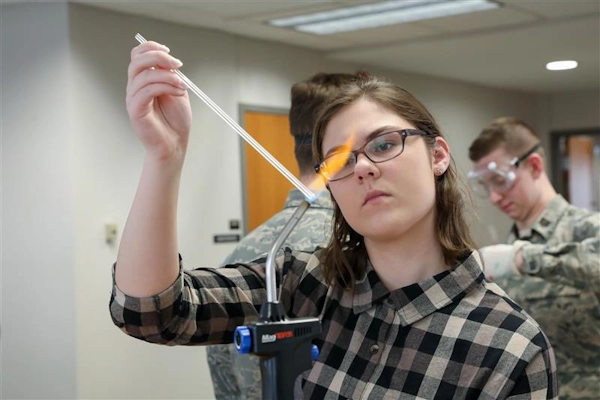 A student heats a glass tube to create a thermometer