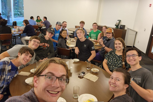Students and faculty pose while at a dining center