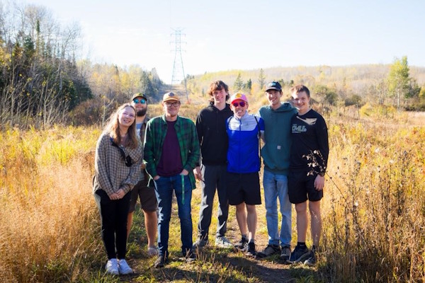 Students pose on-location in a field