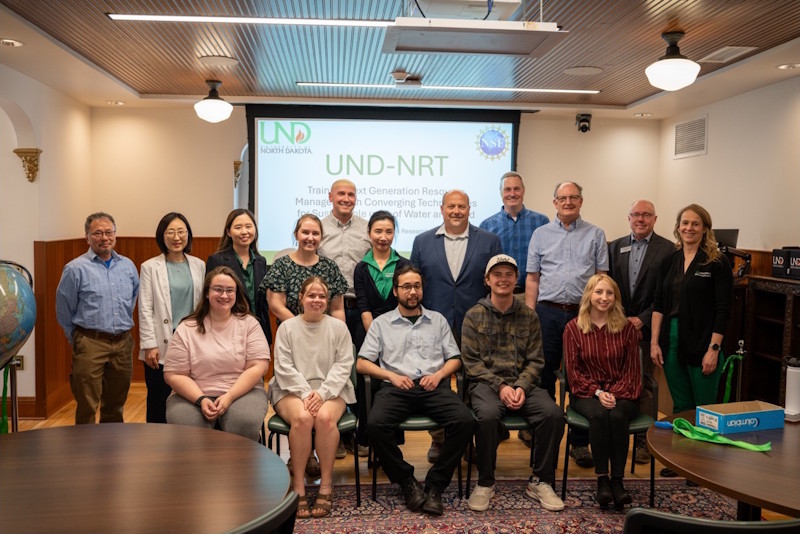 A group, including the members of the leadership team, in front of a STREAM-NRT presentation